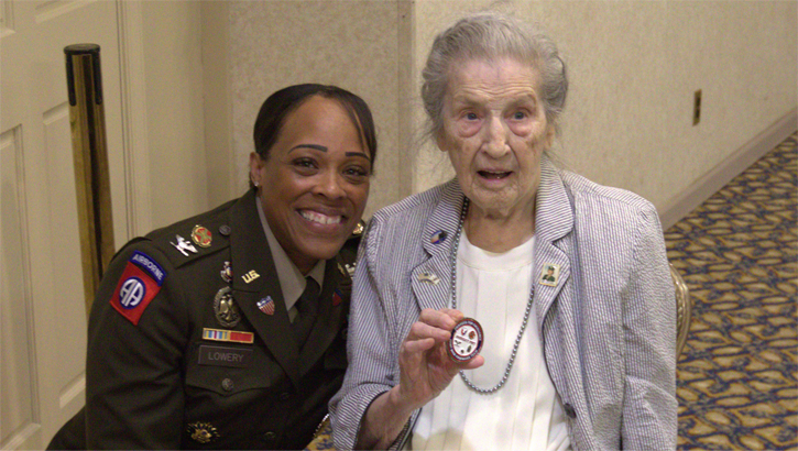 Joint Base Myer-Henderson Hall Commander Col. Tasha Lowery (left) poses with 2nd Lt. Regina Benson, who shows off the challenge coin she was presented, during a brunch