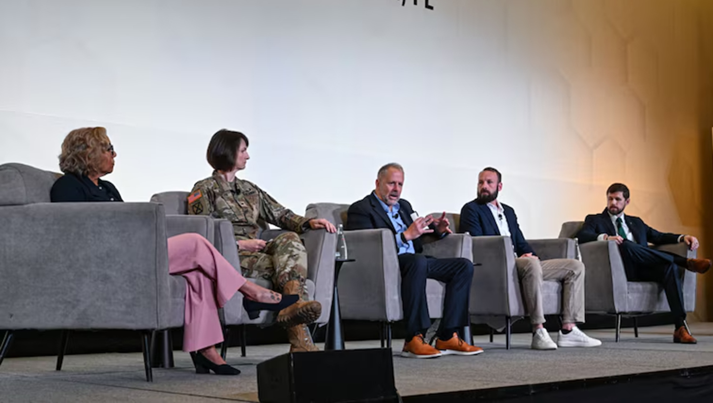 Retired Army Maj. Gen. Clayton M. Hutmacher, center, speaks on the optimizing human performance panel
