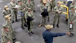 Seaman directing training personnel onboard ship.