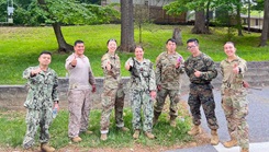 U.S. service members assigned to the Enlisted to Medical Degree Preparatory Program give thumbs-up gestures