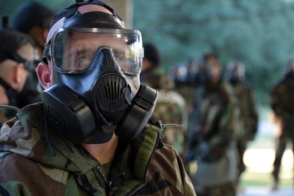 Photo of service member in uniform with gas mask on for training 