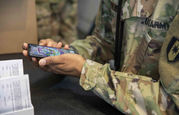 Image of a soldier looking at his cell phone
