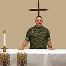 Chaplain poses at the alter