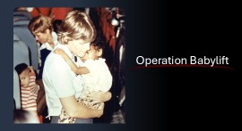 Operation Babylift nurse holding a child on board a transport plane.