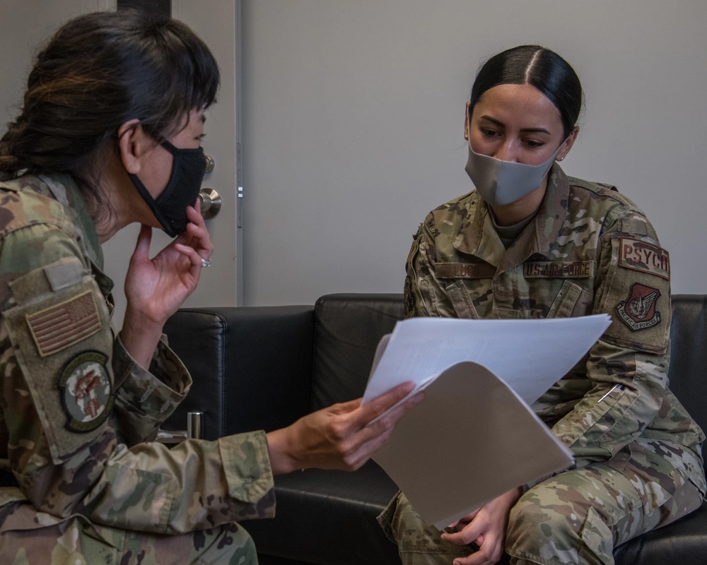 Image of U.S. Air Force Airman 1st Class Miranda Lugo, right, 18th Operational Medical Readiness Squadron mental health technician and Guardian Wingman trainer, and Maj. Joanna Ho, left, 18th OMRS director of psychological health, discuss the suicide prevention training program, Guardian Wingman, at Kadena Air Base, Japan, Aug. 20, 2021. Guardian Wingman aims to promote wingman culture and early help-seeking behavior. (U.S. Air Force photo by Airman 1st Class Anna Nolte).