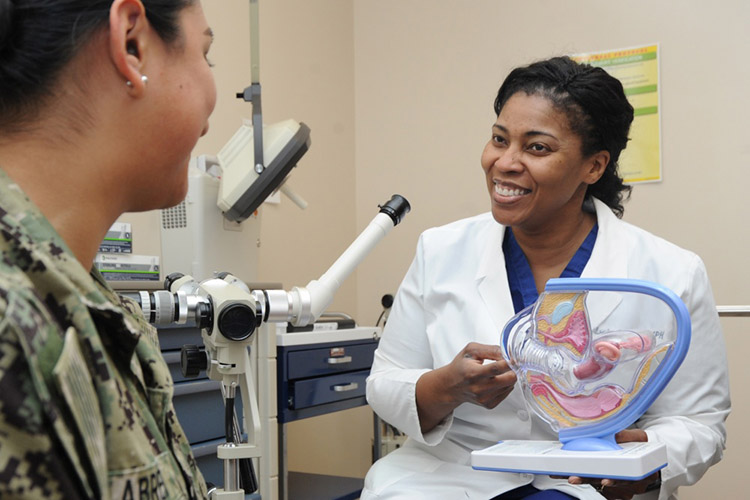 Image of Lt. Cmdr. Leslye Green, staff obstetrician and gynecologist, Naval Hospital Pensacola (NHP), uses a model to discuss cervical cancer with a patient at NHP. According to the Centers for Disease Control and Prevention (CDC), cervical cancer is highly preventable because screening tests for cervical cancer and vaccines to protect against human papillomavirus (HPV), which is the main cause of cervical cancer, are readily available. Cervical cancer is highly treatable and associated with long survival and good quality of life when it is detected early. (U.S. Navy photo by Mass Communication Specialist 1st Class Brannon Deugan).