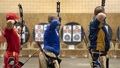 Three men shooting arrows at targets