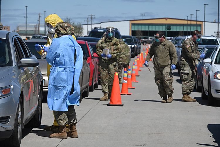 Staff Sgt. Misty Poitra and Senior Airman Chris Cornette, 119th Medical Group, collect throat swabs during voluntary COVID-19 rapid drive-thru testing for members of the community while North Dakota Army National Guard Soldiers gather test-subject data in the parking lot of the FargoDome in Fargo, N.D., May 3, 2020. The guardsmen partnered with the N.D. Department of Health and other civilian agencies in the mass-testing efforts of community volunteers. (U.S. Air National Guard photo by Chief Master Sgt. David H. Lipp)