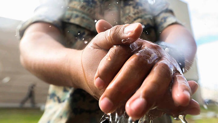 Image of Marines with Marine Wing Headquarters Squadron, 3rd Marine Aircraft Wing take precautionary measures by cleaning and disinfecting their hands during field day on Marine Corps Air Station Miramar, Calif., March 20, 2020, to mitigate the spread of COVID-19 while continuing to perform mission-essential tasks. (Photo: Marine Corps Lance Cpl. Jaime Reyes).