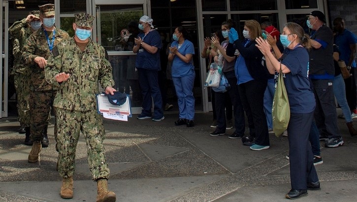 Image of Healthcare workers applauding departing soldiers. Click to open a larger version of the image.