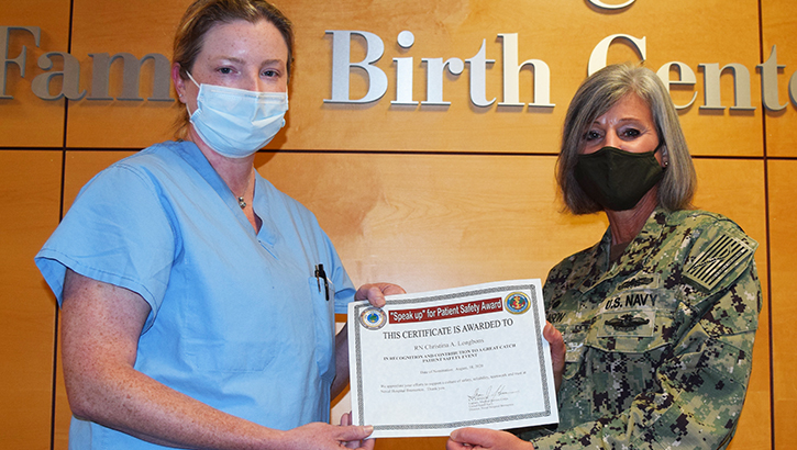 Military personnel gives nurse an award