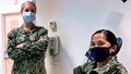 Image of two military personnel wearing masks
