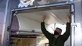 Man wearing mask, looking at ceiling of an airplane