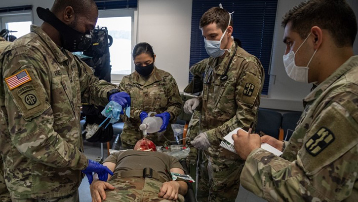Image of Soldiers practicing burn care on dummies.