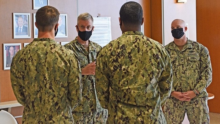 Four military personnel in uniform, wearing masks