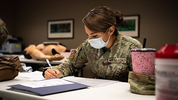 Soldier sitting at a table, wearing a mask, taking a test