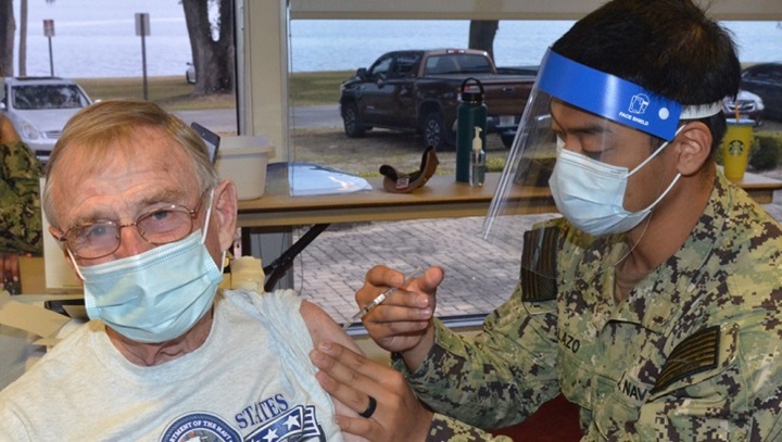 Image of Military medical personnel giving a vaccine shot to a soldier.