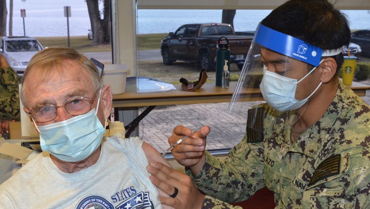 Military medical personnel giving a vaccine shot to a soldier