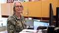 Military officer sitting at her desk and smiling