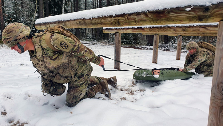 Soldiers in the snow, pulling a sled of materials