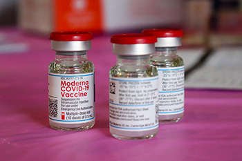 Three vials of COVID-19 vaccine on a table