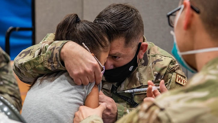 A parent comforts his child while she receives a pediatric dose of the COVID-19 vaccine at Kadena Air Base, Japan, Jan. 28, 2022. (Photo: Airman 1st Class Anna Nolte, 18th Wing Public Affairs)