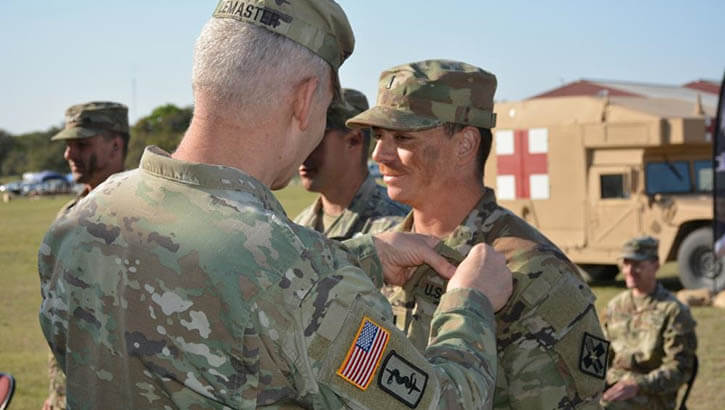 Military personnel share an EFMB badge award moment.