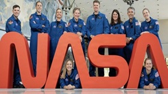 Military personnel standing in front of a NASA sign