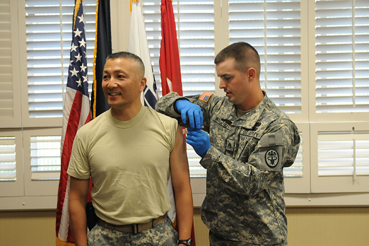 Image of Staff Sgt. James H. Wagner, William Beaumont Army Medical Center, vaccinates Maj. Gen. M. Ted Wong, commanding general, William Beaumont Army Medical Center, with the seasonal flu vaccines. Click to open a larger version of the image.
