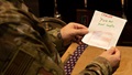 Image of soldier holding a letter. 