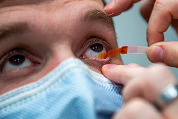Air Force Staff Sgt. Dalton Aric, 31st Civil Engineer Squadron firefighter, has a fluorescein strip touch his eye during an eye exam at Aviano Air Base, Italy, Dec. 2, 2021. Fluorescein is used to assist in the detection of debris and corneal abrasions. (Photo: Senior Airman Brooke Moede, 31st Fighter Wing Public Affairs)
