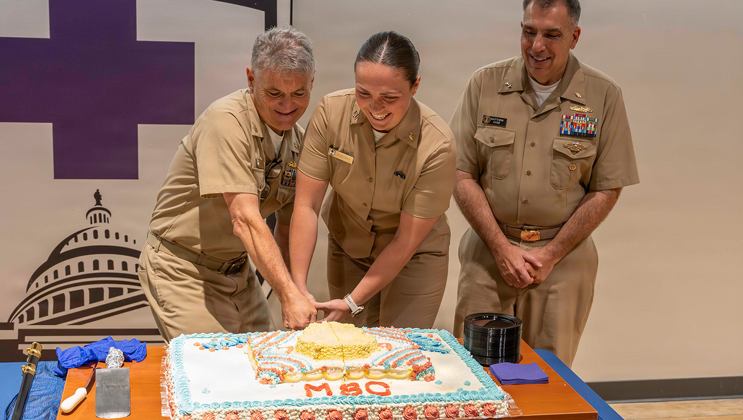 Rear Adm. Matthew Case, Acting Surgeon General Director of the Medical Service Corps, Capt. David Lang, executive officer, Navy Medicine Readiness and Training Center and Lt. Adrianna Kuechle cutting cake