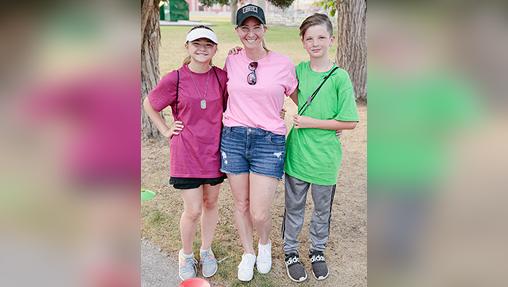Image of Ashley Warren, a volunteer military spouse, poses with her two kids in attendance during the annual UTNG-Kids summer camp at Camp Williams, Utah, June 28, 2022. Utah National Guard Youth Programs hosts this summer camp each year, inviting kids within specific age groups to come experience team building, crafts, and learning in a safe and fun environment. (U.S. Army National Guard photo by Staff Sgt. Jordan Hack) .