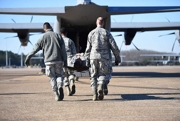 Airmen from the 19th Medical Group litter-carry a simulated patient onto a C-130J during an aeromedical evacuation training mission at Little Rock Air Force Base in 2019. (Photo Courtesy of U.S. Air Force)