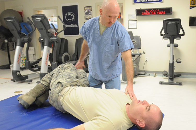Image of U.S. Air Force Capt. Sean Wilson, a native of Winston-Salem, N.C., and a physical therapist with the 59th Orthopedic and Rehabilitation Squadron, teaches a patient some home exercises that he can perform on his own at the Craig Joint-Theater Hospital, Jan. 23, 2012. (U.S. Air Force photo by Spc.Cody Barber, Bagram Air Field, Afghanistan/Released). Click to open a larger version of the image.
