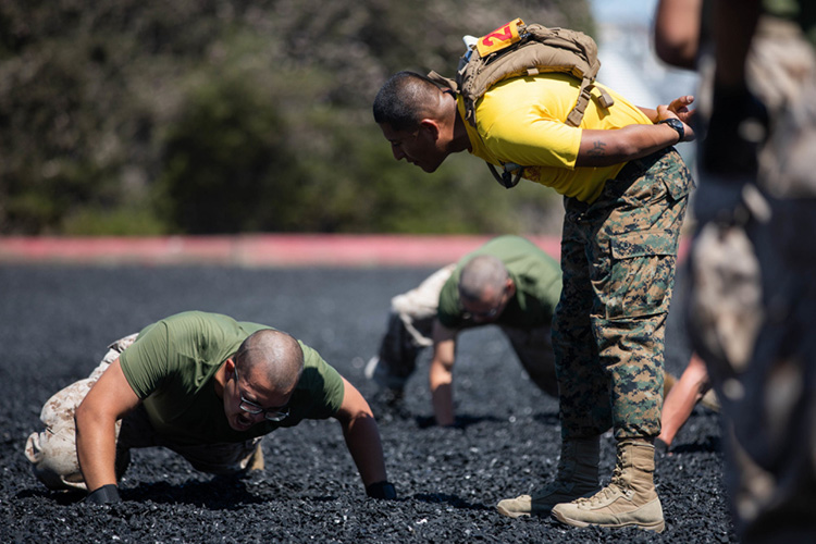 A U.S. Marine Corps drill instructor with Golf Company, 2nd Recruit Training Battalion, motivates a recruit during a Marine Corps Martial Arts Program (MCMAP) training session at Marine Corps Recruit Depot, San Diego, Aug. 2, 2021. The drill instructors ensured recruits conducted the techniques safely and effectively during the training session. (U.S. Marine Corps photo by Cpl. Zachary T. Beatty)