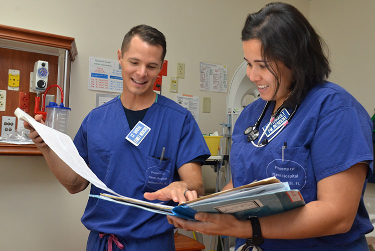 Image of Naval Hospital Jacksonville physicians Lt. Catherine Perrault, right, and Lt. Joseph Sapoval review patient charts at the hospital’s labor and delivery unit. Perrault, from Orlando, Florida, rendered aid at the scene of an accident involving a train and a school bus on Sept. 27, 2018. Perrault recently returned from a deployment to the Middle East where she served as the general medical officer aboard the amphibious assault ship USS Iwo Jima (LPH 2). During the deployment, she provided routine, acute, and critical care. (U.S. Navy photo by Jacob Sippel/Released). Click to open a larger version of the image.