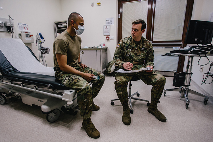 Image of A U.S. Army nurse paratrooper provides patient care in support of preventative efforts against COVID-19. Click to open a larger version of the image.