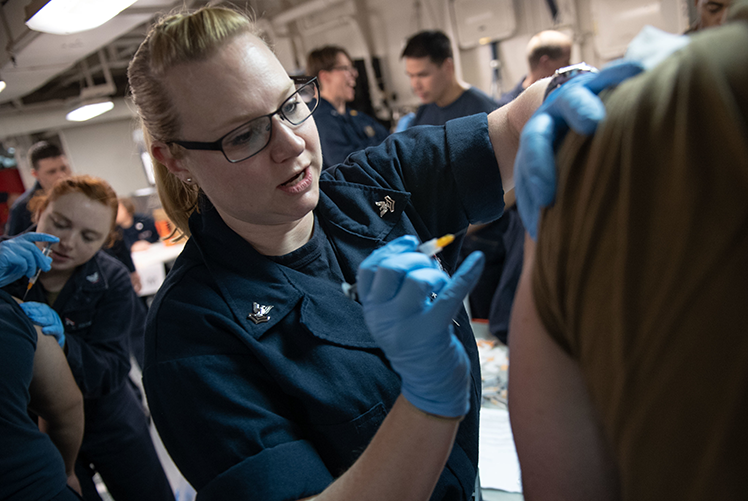 Image of Adminstration of a seasonal flu vaccination. (U.S. Navy photo). Click to open a larger version of the image.