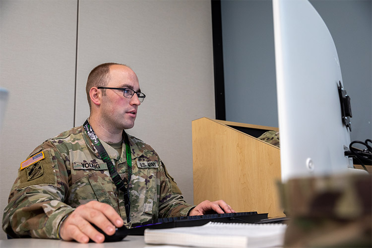 NIANTIC, CT, UNITED STATES 06.16.2022 U.S. Army Staff Sgt. John Young, an information technology specialist assigned to Joint Forces Headquarters, Connecticut Army National Guard, works on a computer at Camp Nett, Niantic, Connecticut, June 16, 2022. Young provided threat intelligence to cyber analysts that were part of his "Blue Team" during Cyber Yankee, a cyber training exercise meant to simulate a real world environment to train mission essential tasks for cyber professionals. (U.S. Army photo by Sgt. Matthew Lucibello)