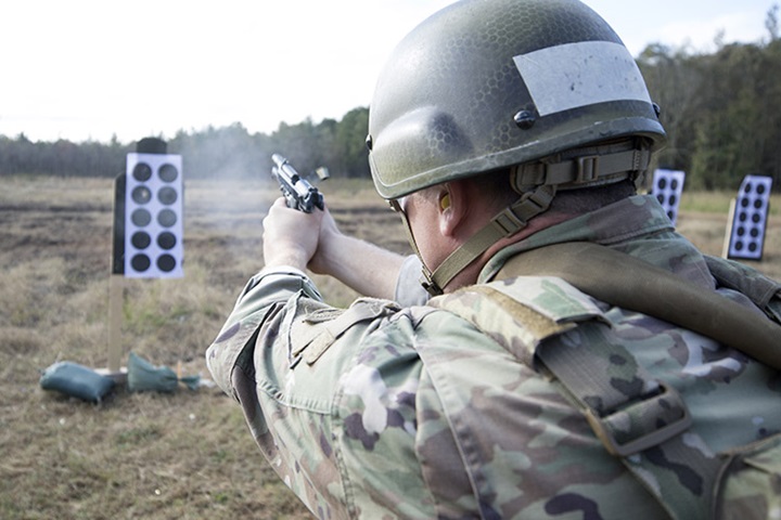 Image of A soldier fires a pistol during small arms training.