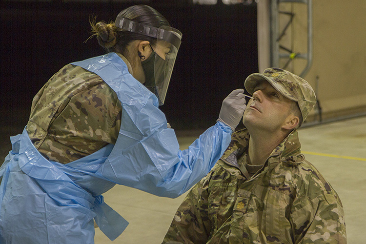 Army Maj. Raymond Nagley, S-3 officer assigned to the 50th Regional Support Group (RSG), receives a nasal swab to screen for COVID-19 at Fort Hood, Texas, on Feb. 5, 2021, from Spc. Yoali Muniz, a lab tech assigned to the 7406th Troop Medical Clinic, based in Columbia, Missouri. The 50th RSG, a Florida Guard unit based in Homestead, Florida, is preparing for deployment to Poland. (U.S. Army Guard photo by Sgt. 1st Class Shane Klestinski)