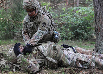 Military personnel stimulating casualty treatment during an operation