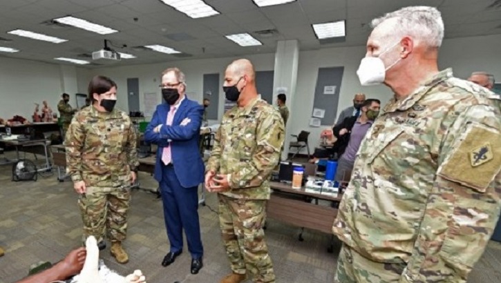 Three soldiers and Mr. McCaffery, wearing masks, talking