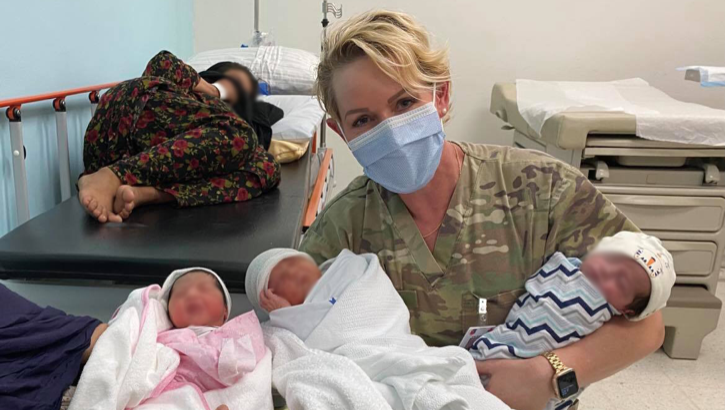 Dr. (Maj.) Elaina Wild, 379th Expeditionary Medical Group chief medical officer, takes a picture with mothers and their newborn babies at Al Udeid Air Base, Qatar. The 379th EMDG was not originally postured for neo-natal care, so medical members had to adapt in order to provide care for evacuating mothers in labor and their newborn babies. Since Al Udeid AB became the main stopover location for qualified evacuees from Afghanistan on Aug. 14, 2021, members assigned to the 379th EMDG helped deliver nine babies. (U.S. Air Force courtesy photo)