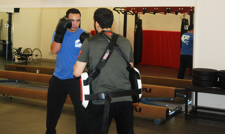 Volunteer boxing coach Mike Martin (right) shows boxing technique to Daniel Irwin, Jr. (Courtesy photo)