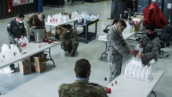 Image of Military personnel packing sanitizing products. Click to open a larger version of the image.