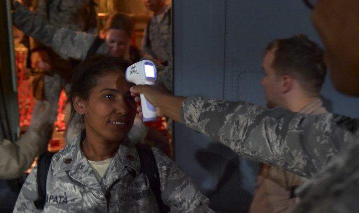 Maj. Mayra Zapata, 633rd Medical Operations Squadron, gets her temperature taken by Tech. Sgt. Saquadrea Crosby, 86th Aerospace Medicine Squadron public health NCOIC, as she deplanes a C-130J Super Hercules at Ramstein Air Base, Germany, Oct. 19, 2014. Any personnel traveling into Ramstein from Ebola infected areas will be medically screened upon their arrival and cleared by public health for onward travel to ensure the health and safety of all passengers, aircrew and members of the Kaiserslautern community. (U.S. Air Force photo/Staff Sgt. Sara Keller)