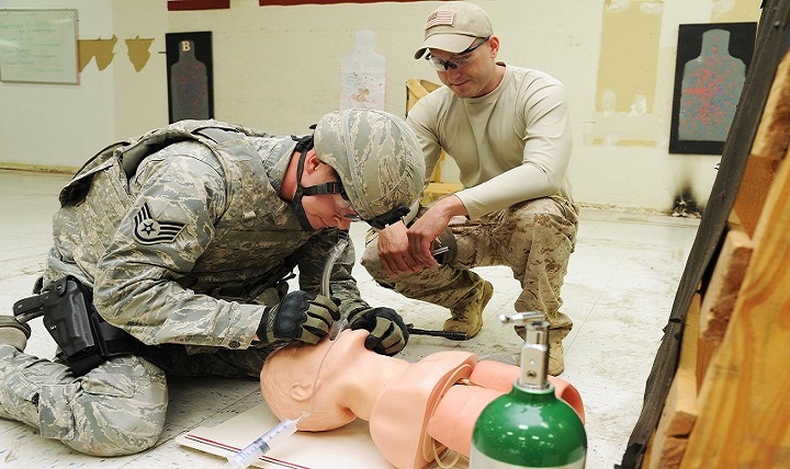 Staff Sgt. Derek Ables (left), 21st Security Forces Squadron, establishes an airway on a simulated patient using a nasopharyngeal tool during a pilot course for Tactical Combat Casualty Care. 