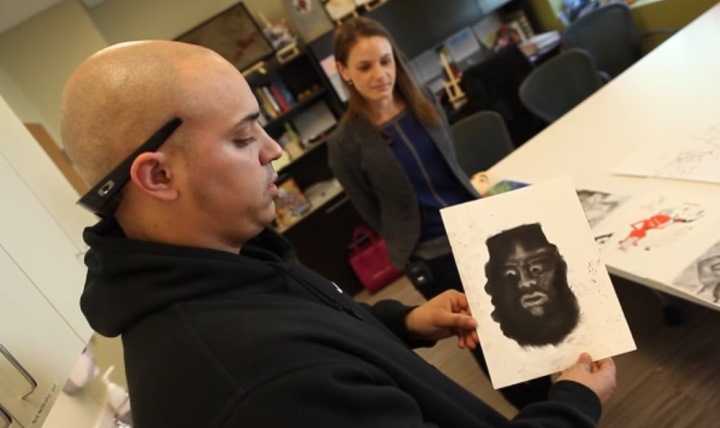 Marine Sgt. Jorden Smith describes his artwork and how art therapy is helping him recover from traumatic brain injury, as therapist Jackie Biggs looks on at the National Intrepid Center of Excellence (NICoE) at Ft. Belvoir, Virginia.